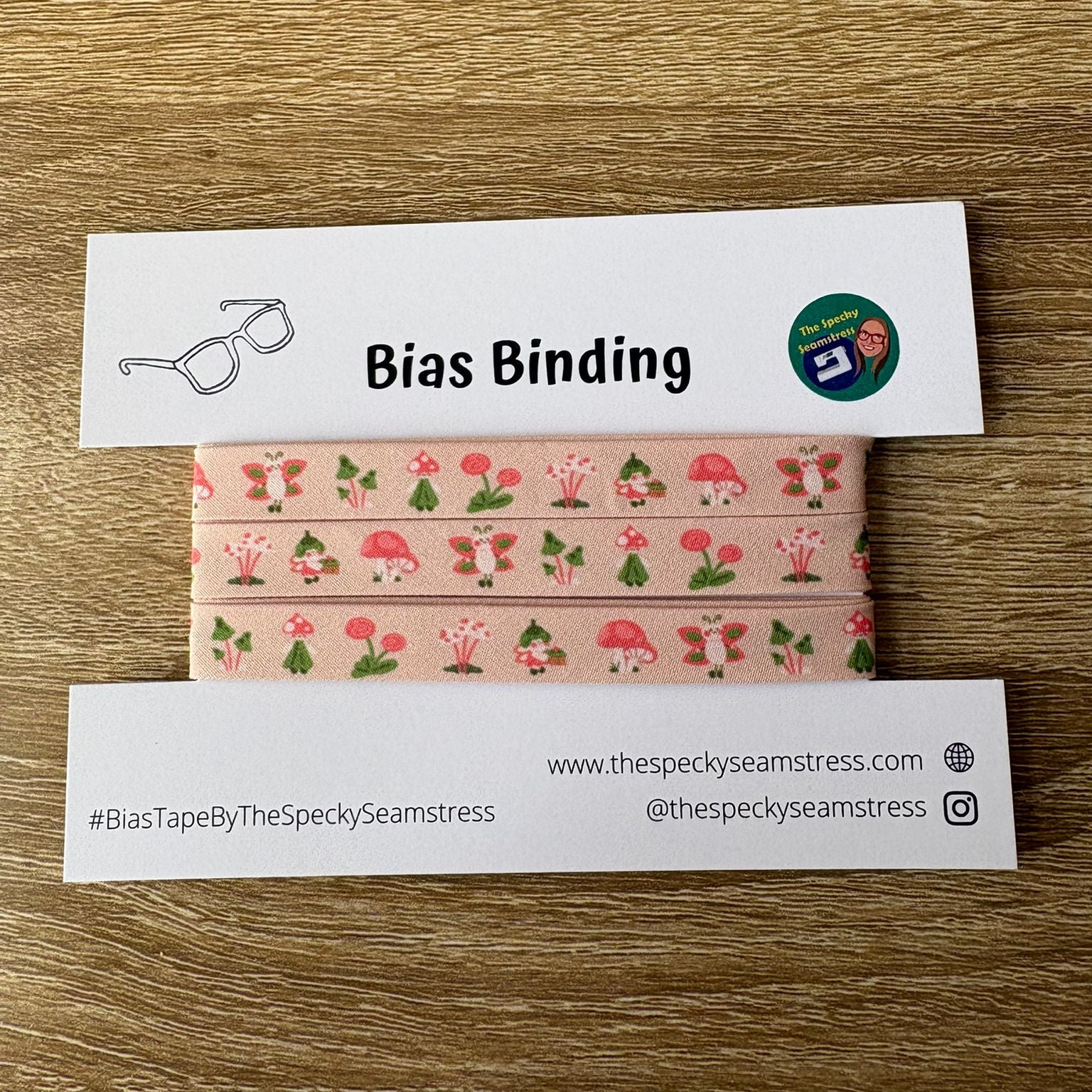 Fairy print Bias binding tape with branding on a wooden surface