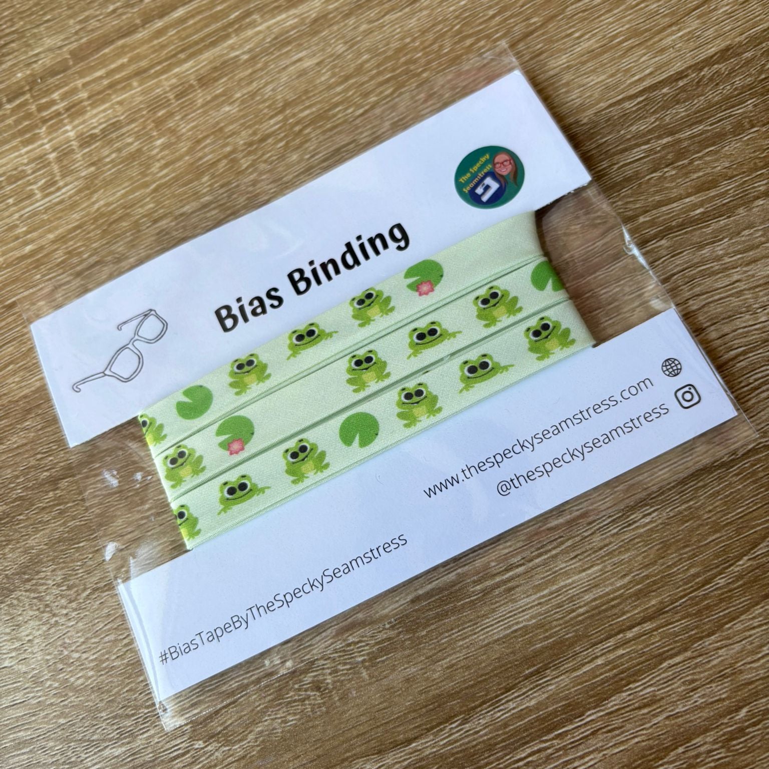 Bias binding with frog pattern on a wooden surface