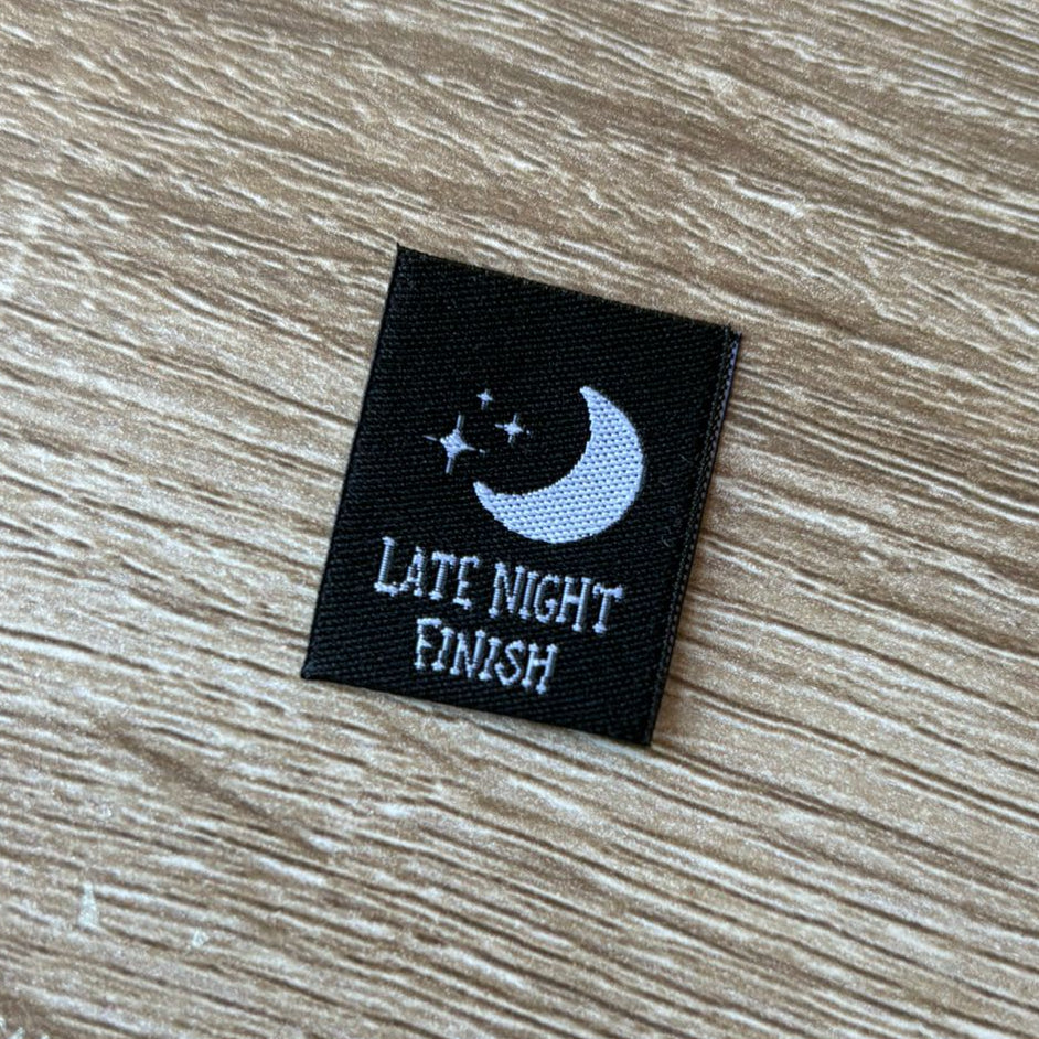 Black label with 'Late Night Finish' text and moon design on a wooden surface