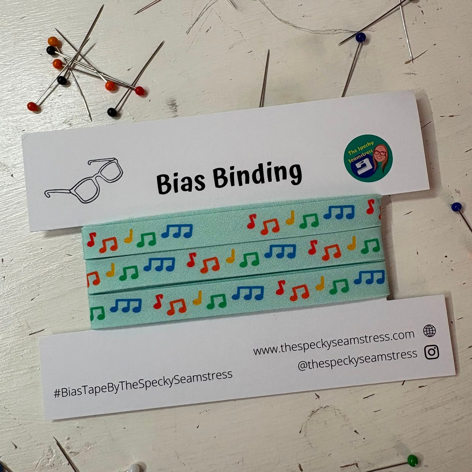 Bias featuring brightly coloured musical notes on a pale blue background, on a white backing card.
