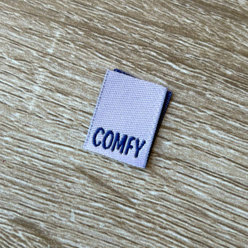 Label with 'COMFY' text on a wooden surface