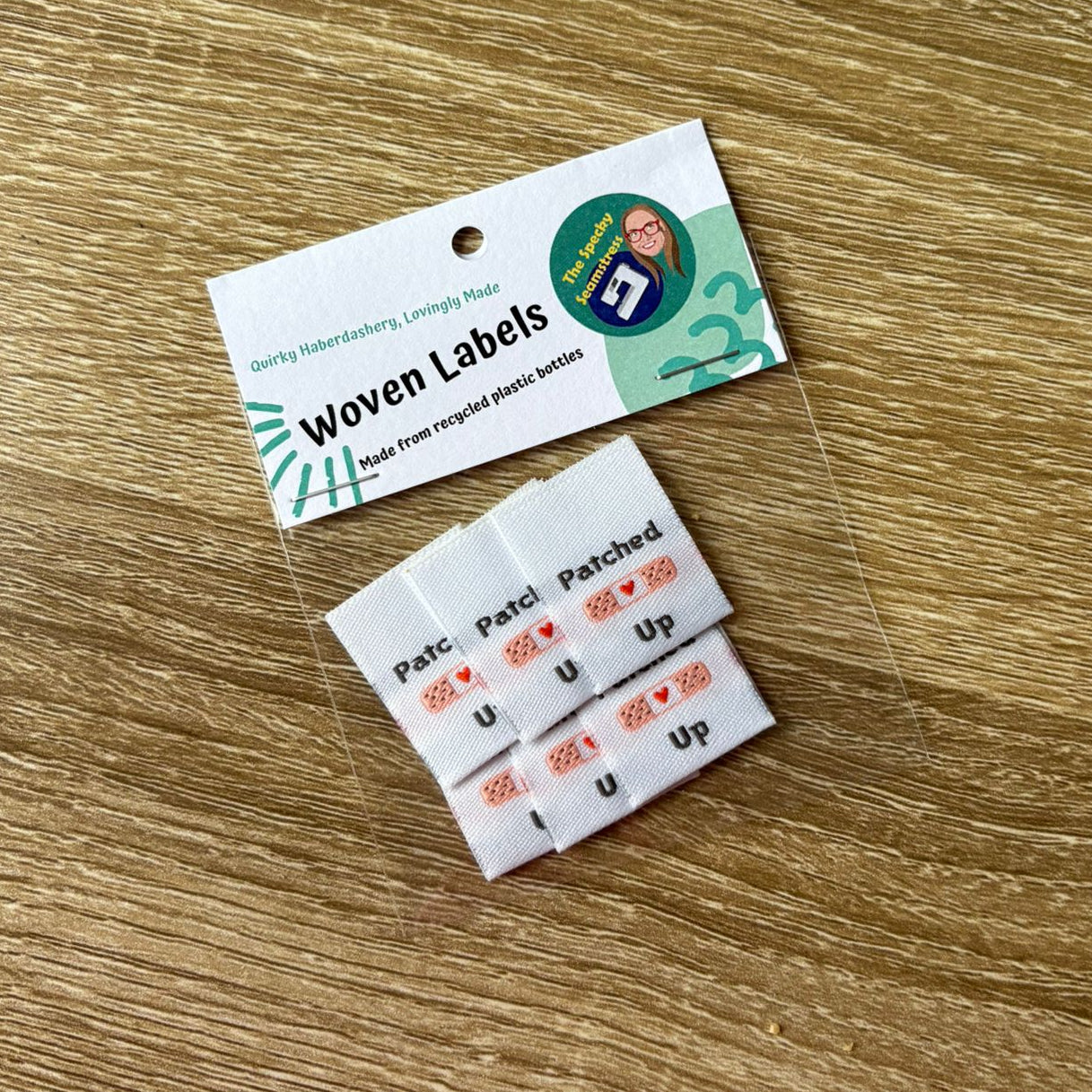 Woven labels on a wooden surface with a label card.