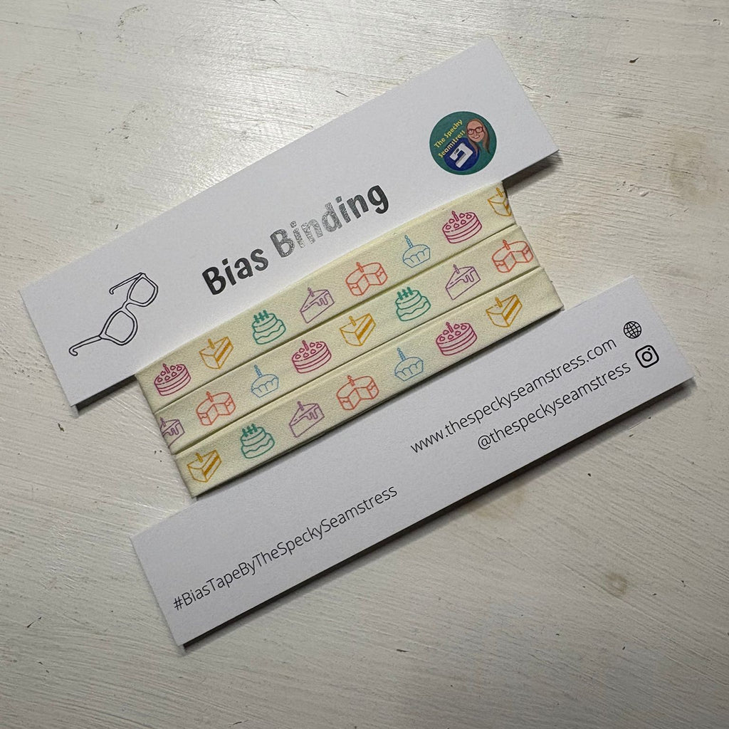 Piece of Cake Bias binding on a white card, on a white wooden table. 