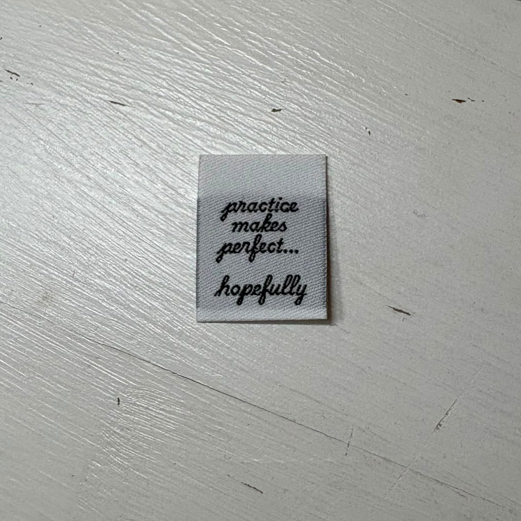 Practice Makes Perfect Hopefully label on a wooden background. 