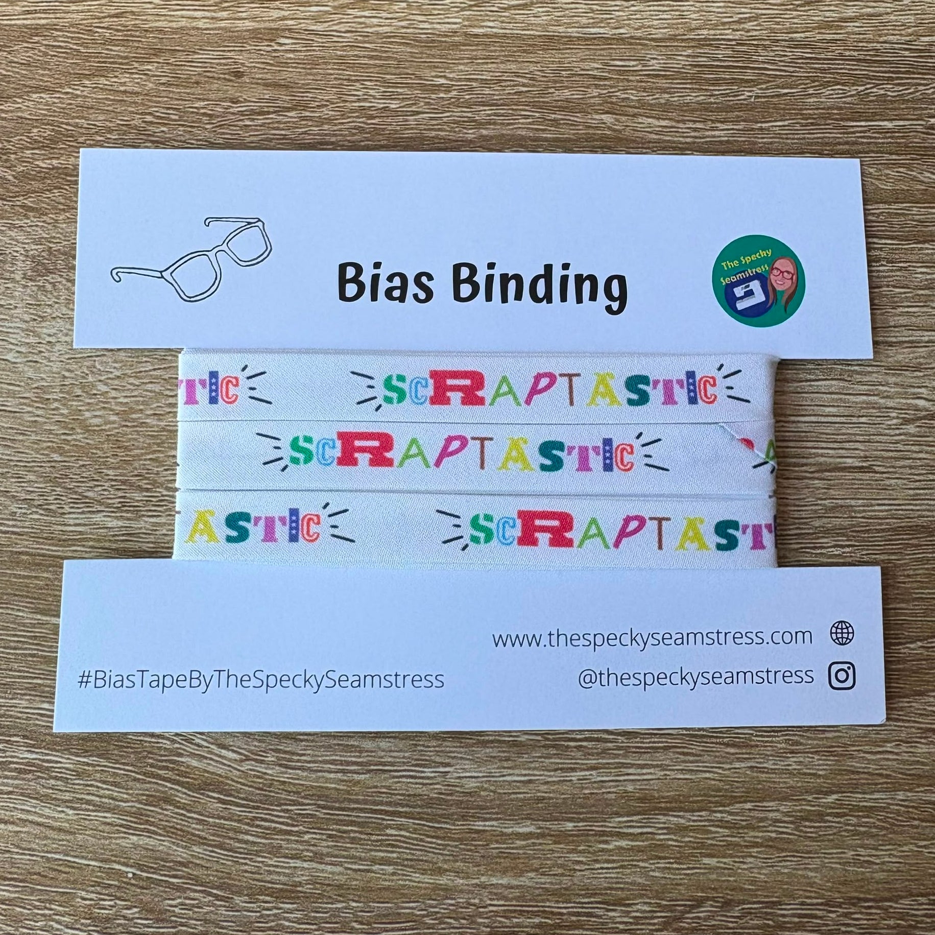 Bias binding tape on a white card with branding on a wooden surface.