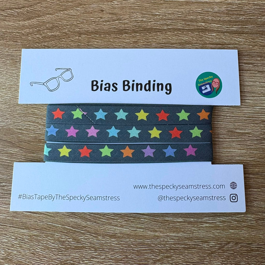 Colorful star-patterned bias binding tape with branded label on a wooden surface