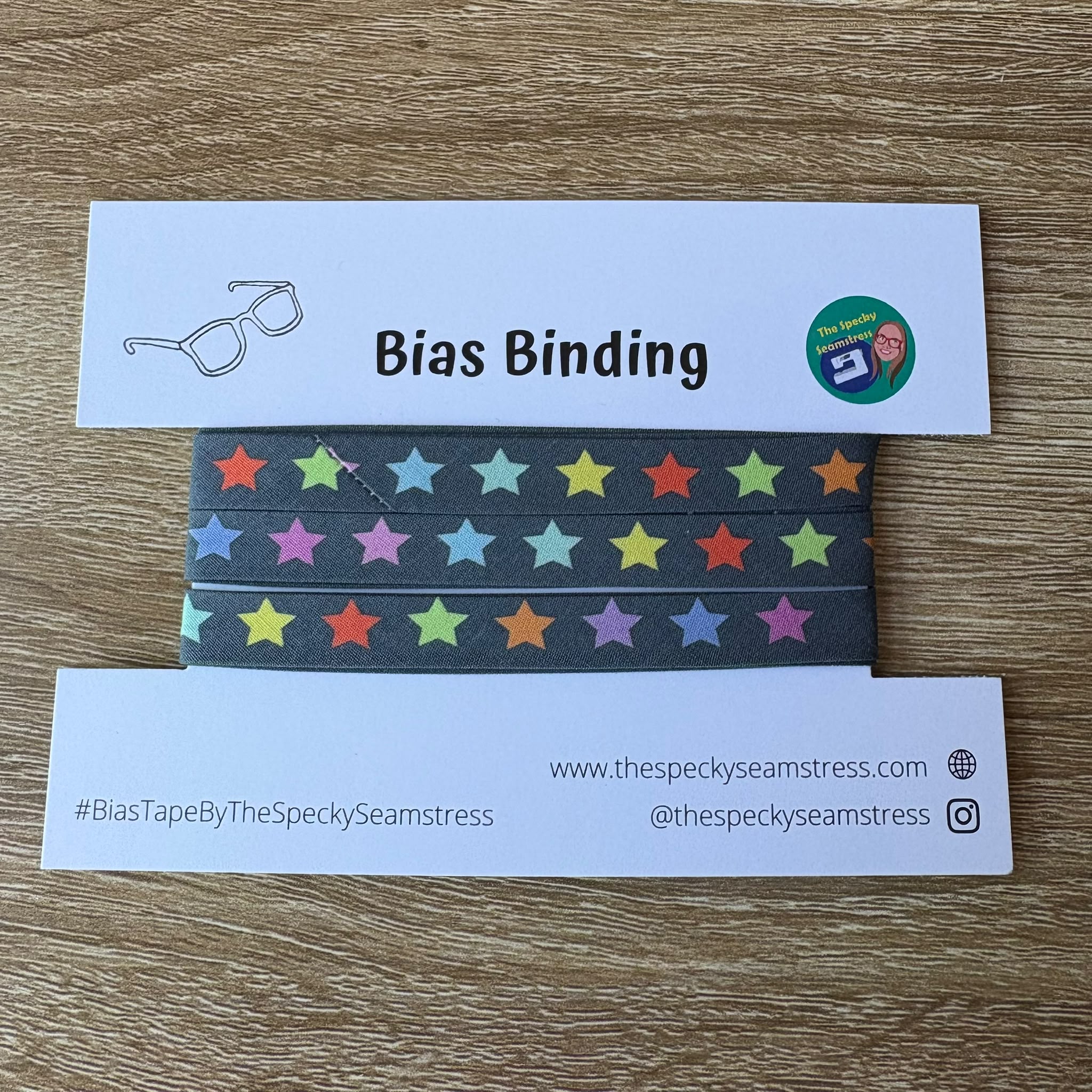 Colorful star-patterned bias binding tape with branded label on a wooden surface