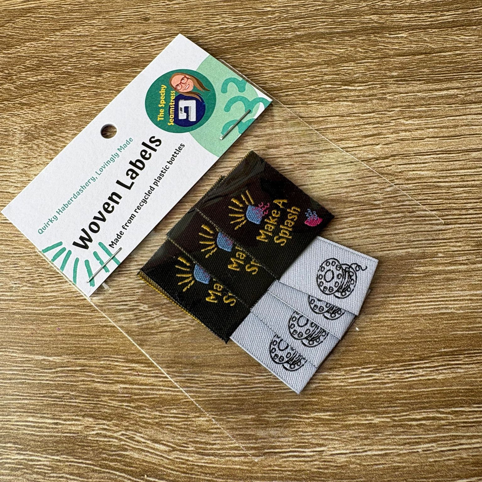 Woven labels on a wooden surface with a label card.