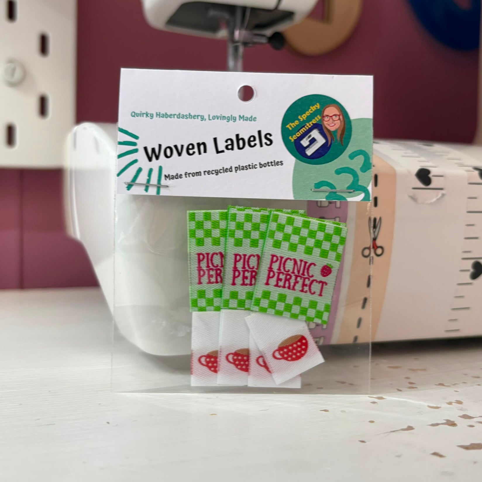 Picnic Perfect and Mini Teacup woven labels with a sewing machine in the background.