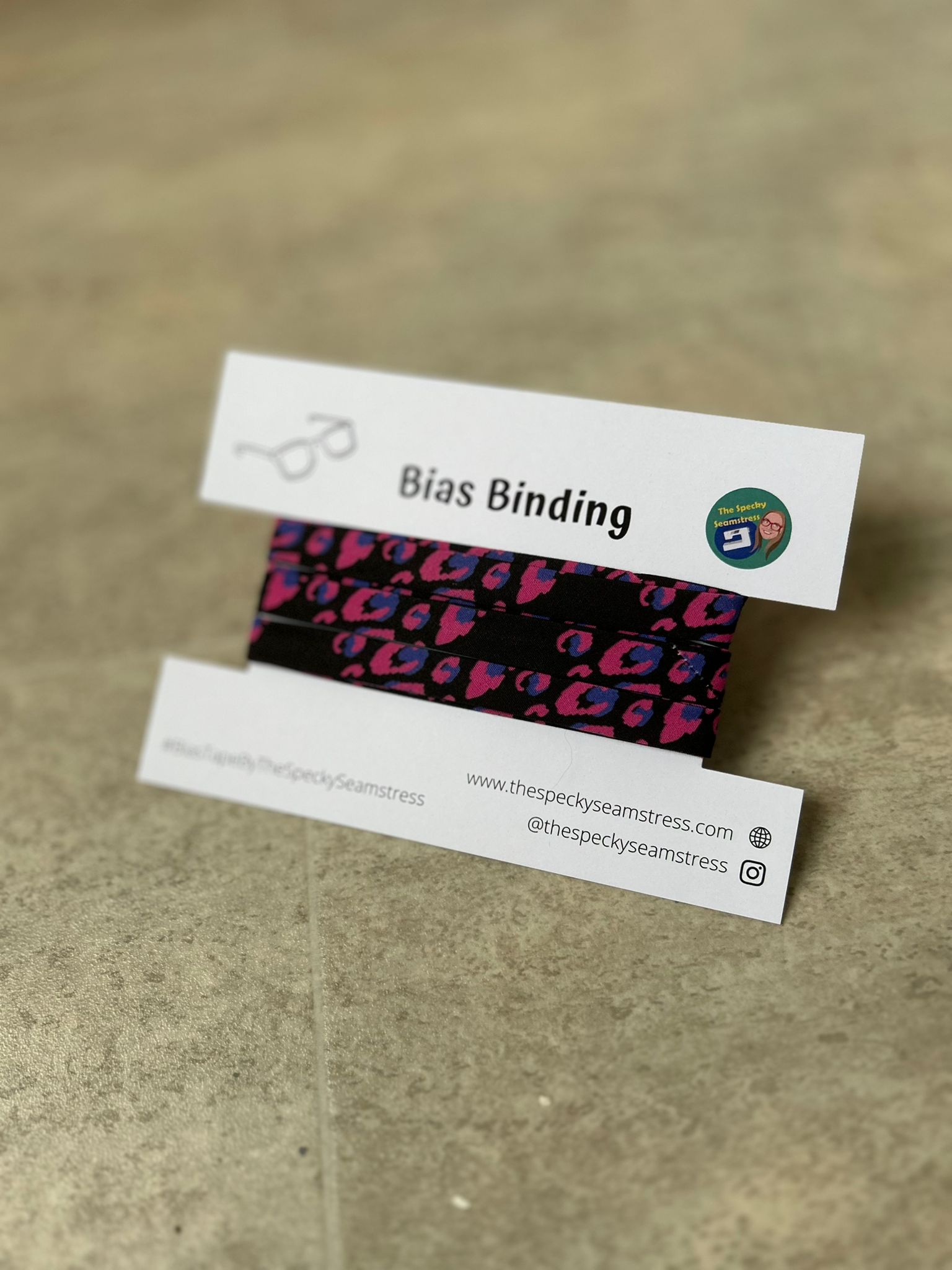 Pink Leopard bias wrapped around a white display card on a cream background.